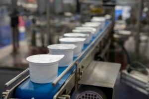 White yogurt packages on a production line in a dairy farm
